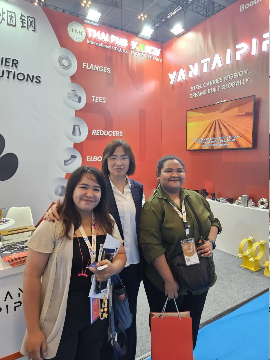 Sales representative and customers at a pipe fittings and flanges booth
